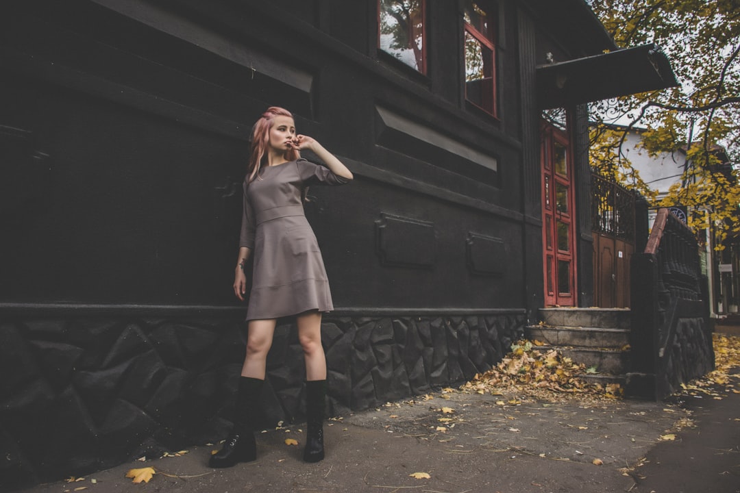 woman standing beside black painted building