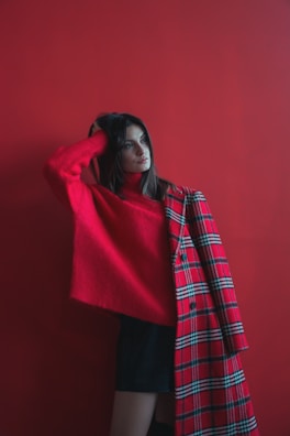Sunlit studio shot of a vibrant red coat draped over a modern chair.