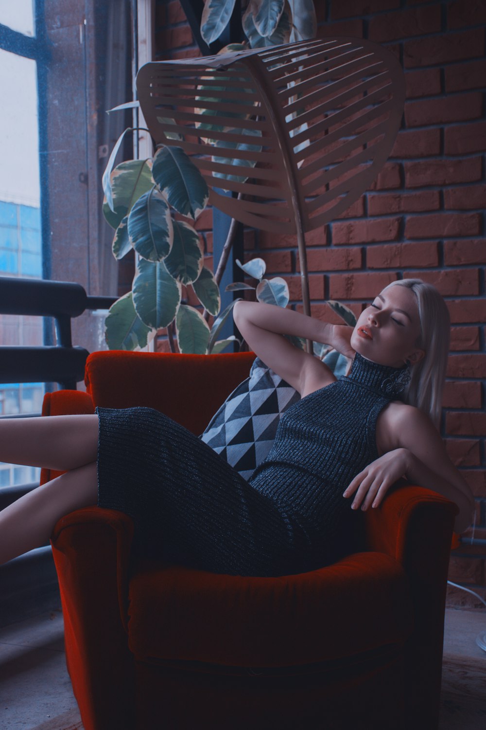 woman sitting on red sofa