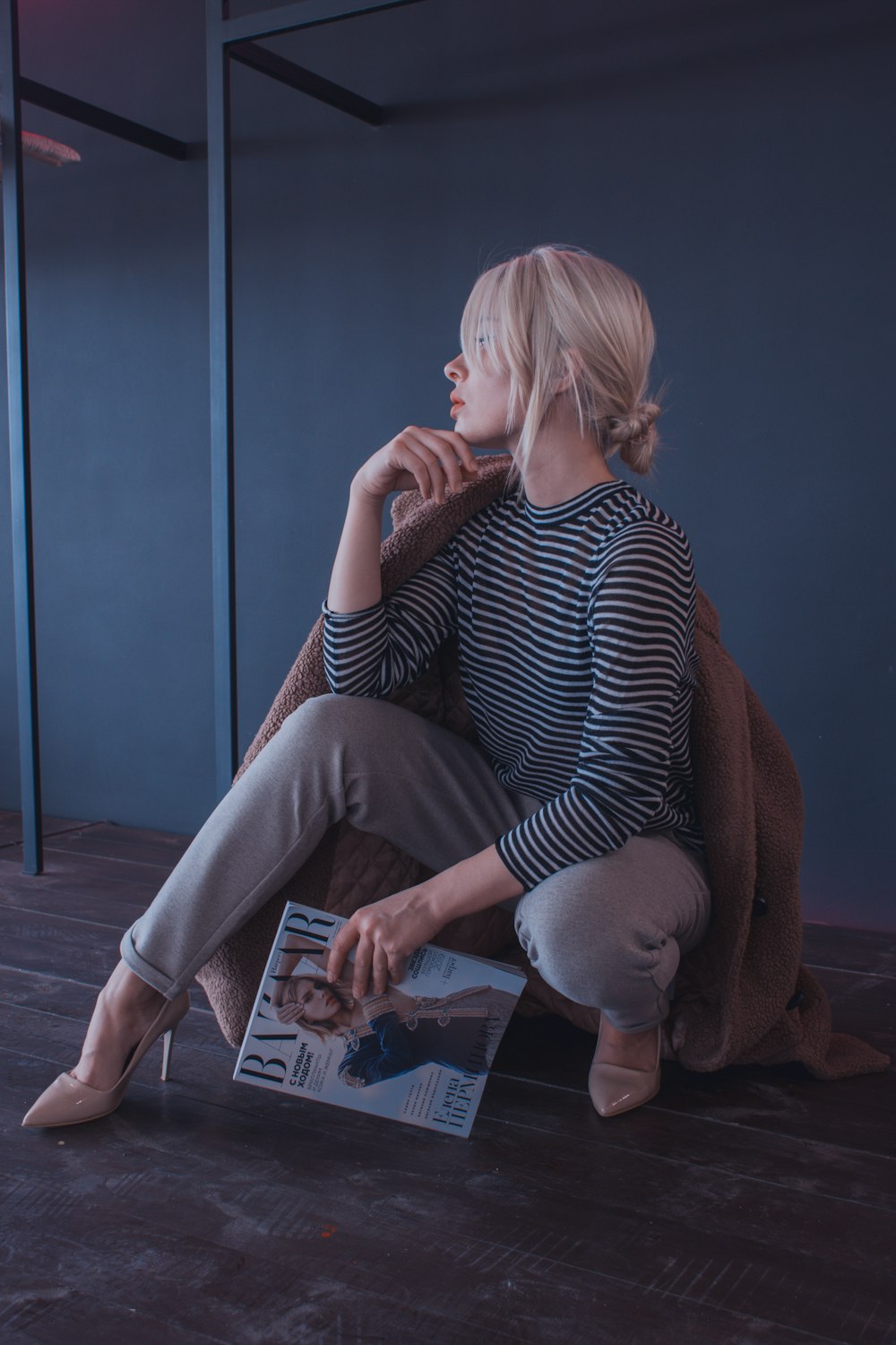 woman holding magazine near the wall