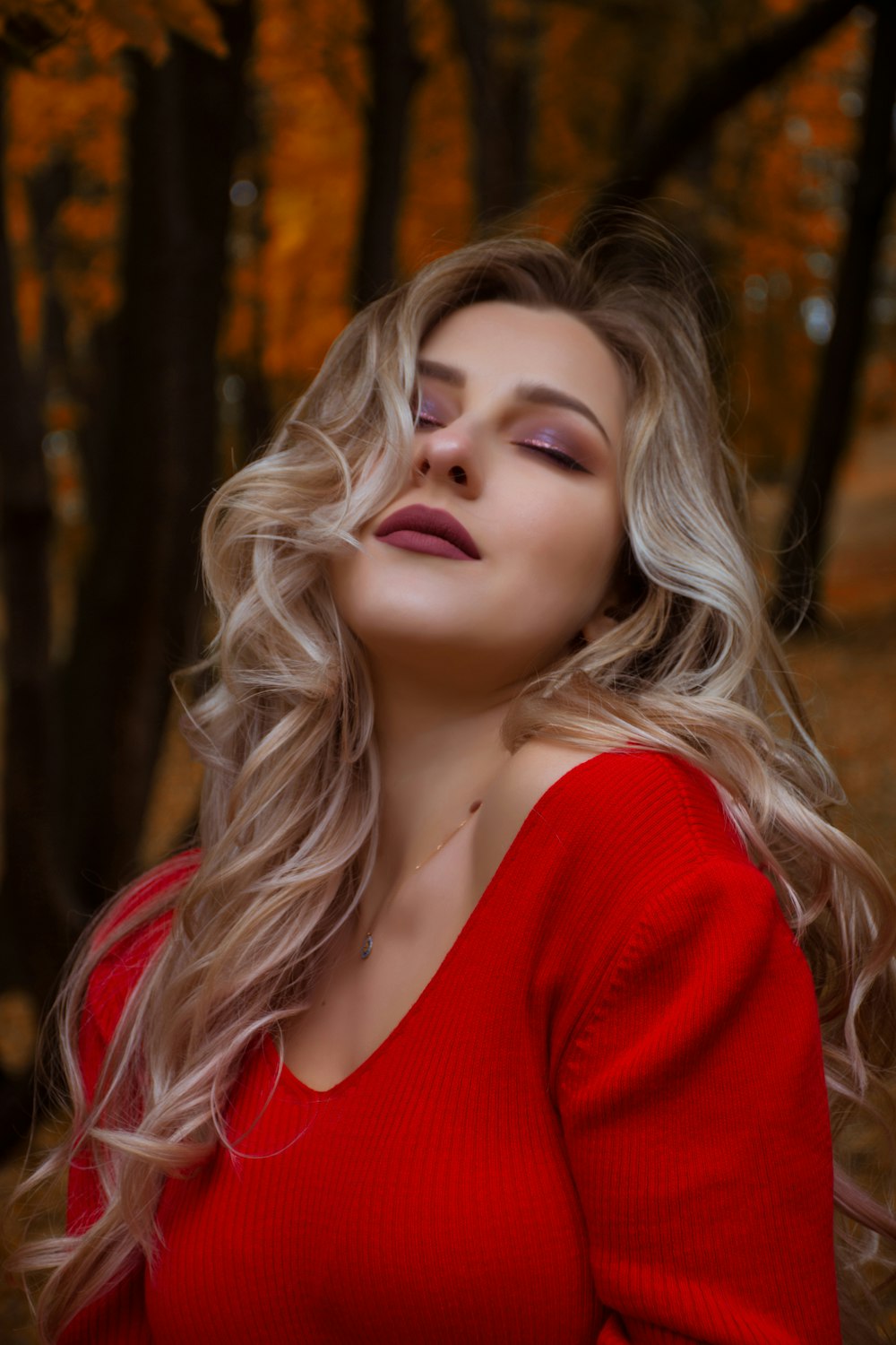 woman in red knit V-neck shirt in forest