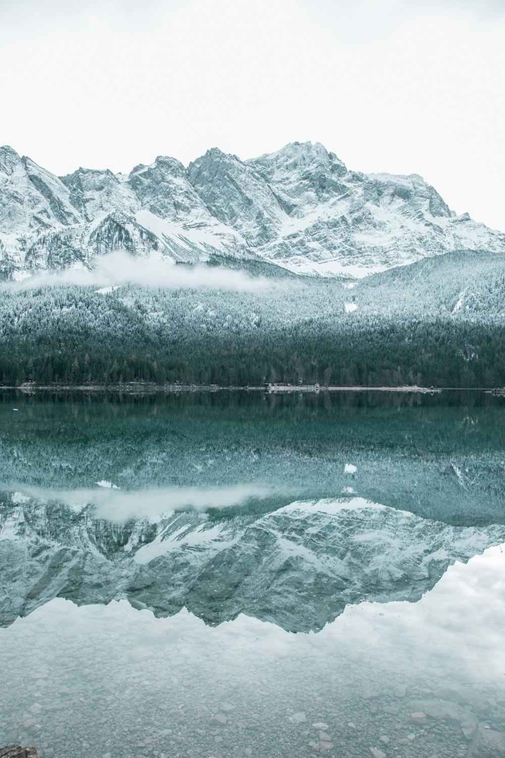 snow-covered mountain near body of water during daytime