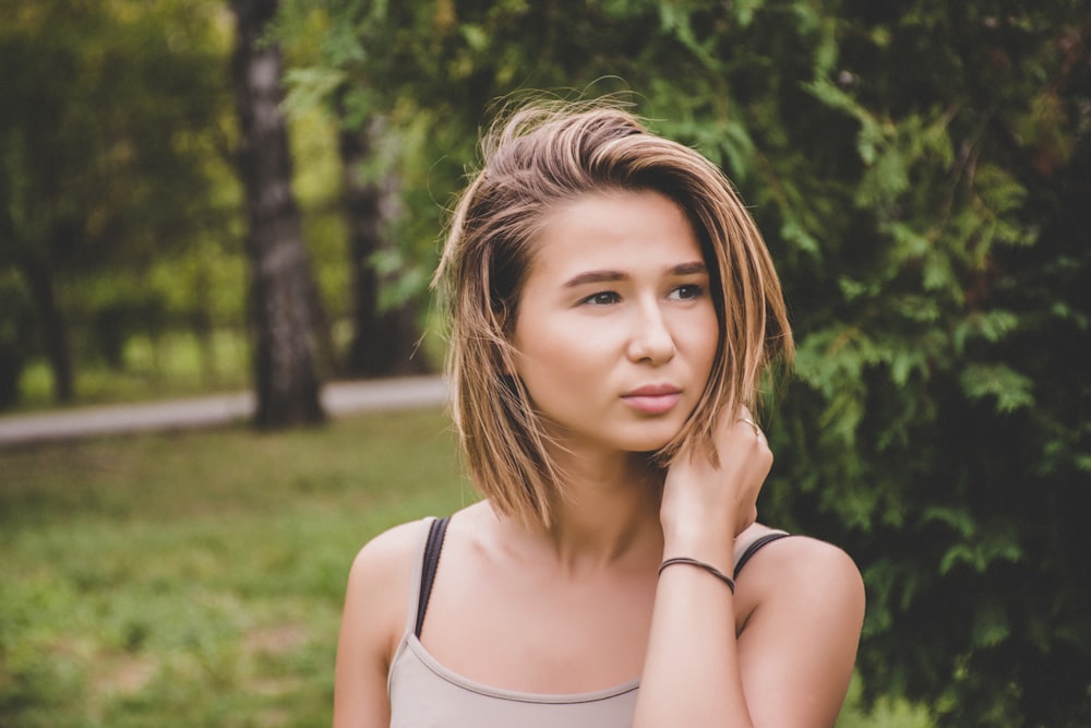 selective focus photography of woman wearing gray spaghetti strap top