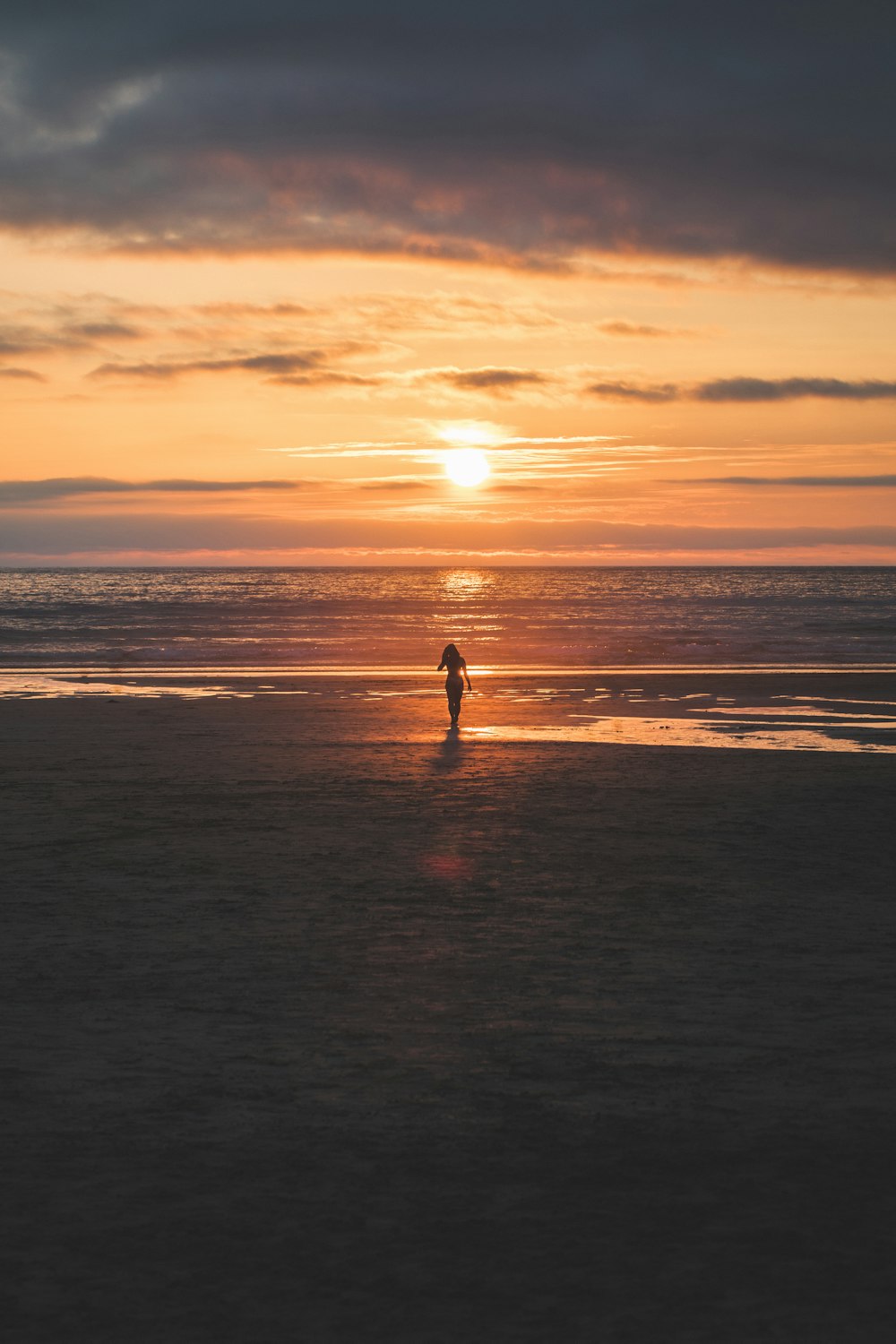 silhouette of woman standing on seashore