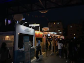Colorful street festival with people enjoying music and local food stalls.