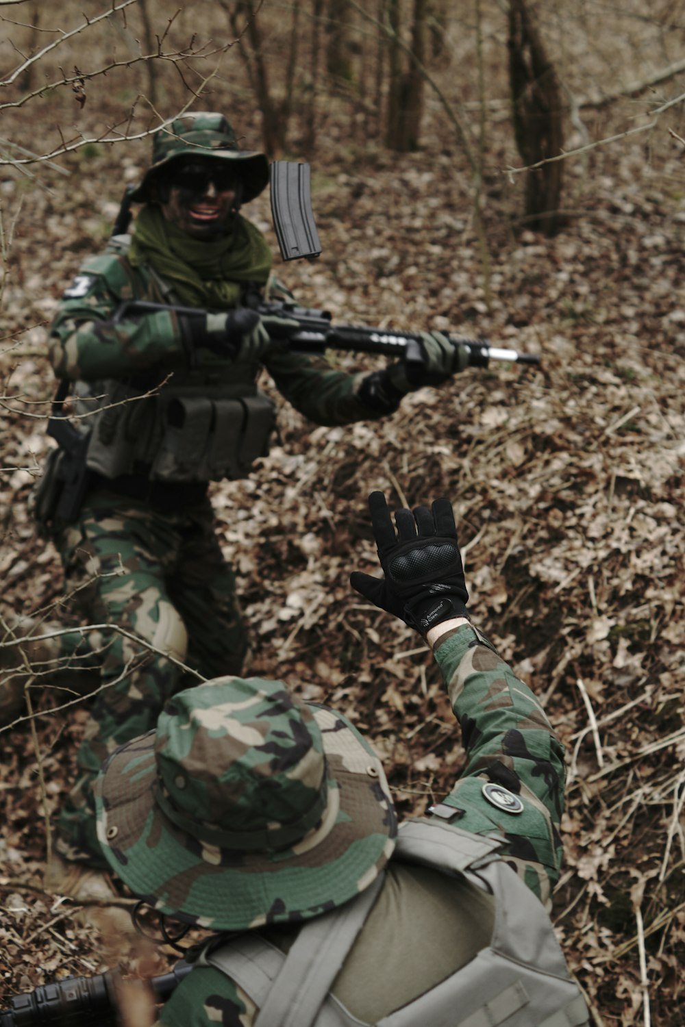 man holding assault rifle in the middle of forest