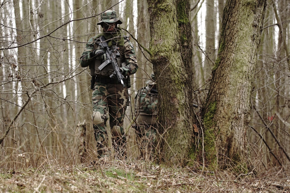 man holding rifle near the tre