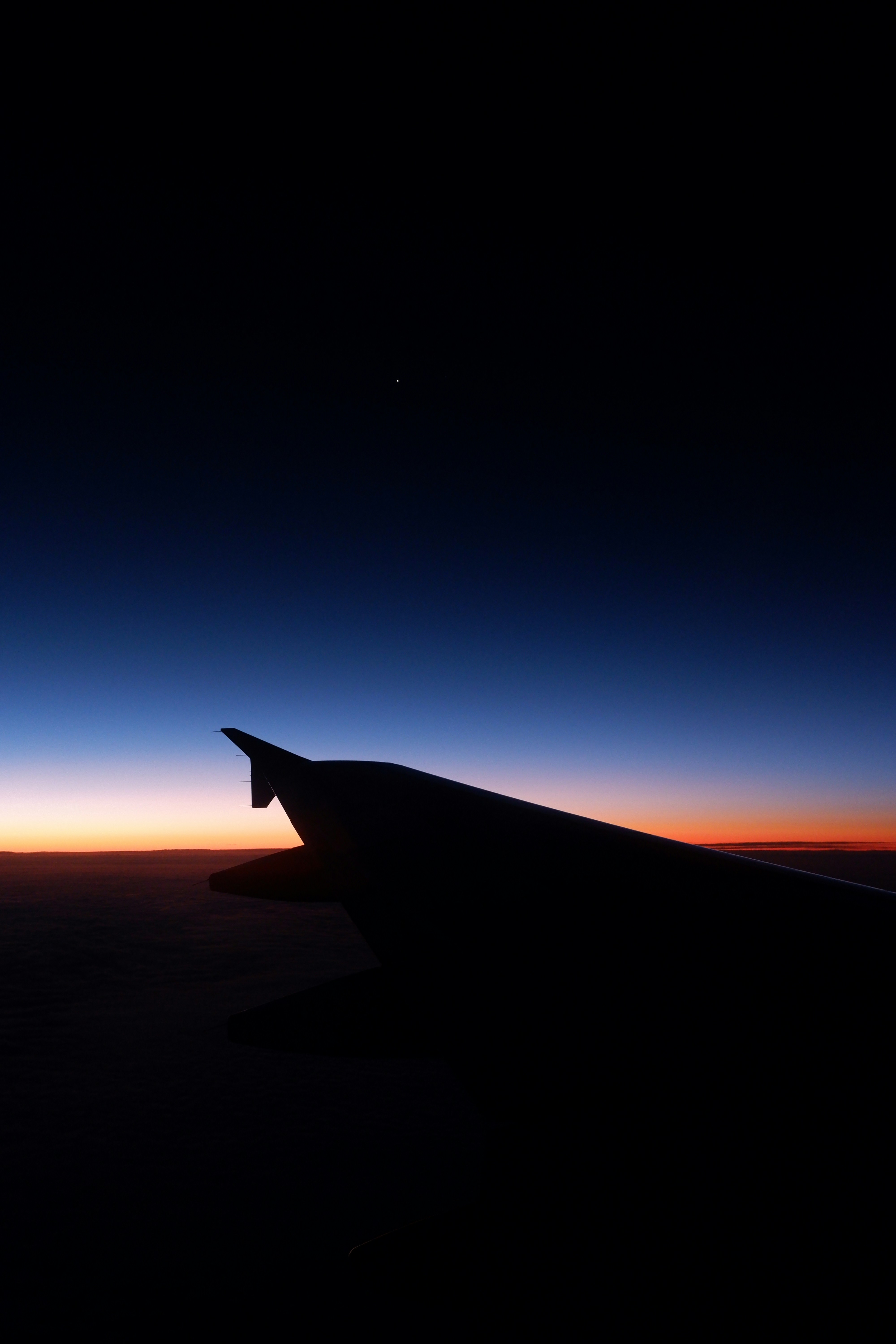 the wing of an airplane as the sun sets