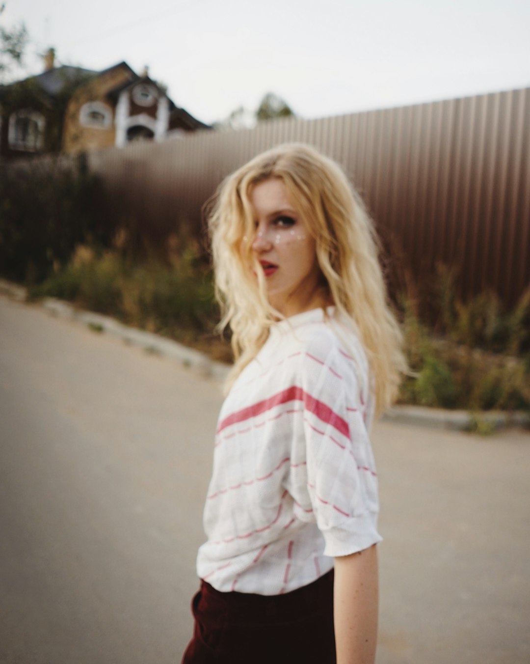 woman standing outside near wall during daytime