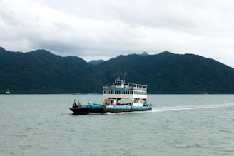 A scenic boat transfer crossing between islands with lush greenery in the background.