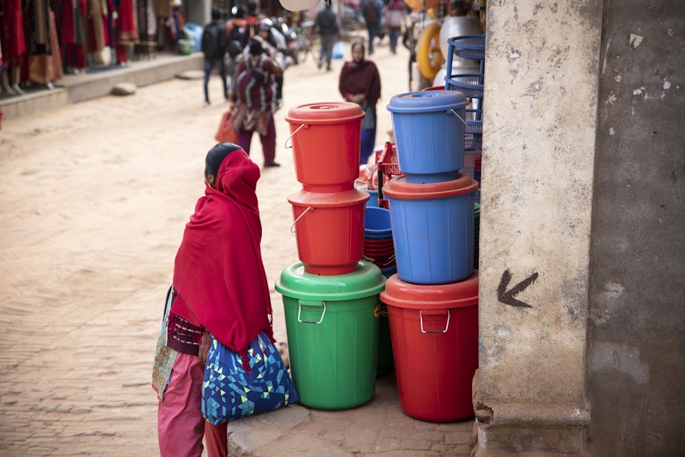 person standing near pile of plastic containers