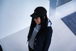 A stylish outfit combining black jeans and a dark hoodie on a wooden floor.