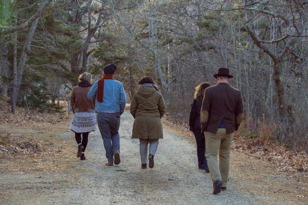 five people walking between trees