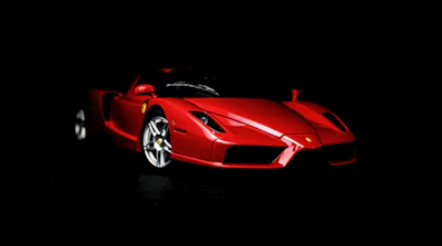 A sleek red car displayed with detailed design highlights and payment plan info.