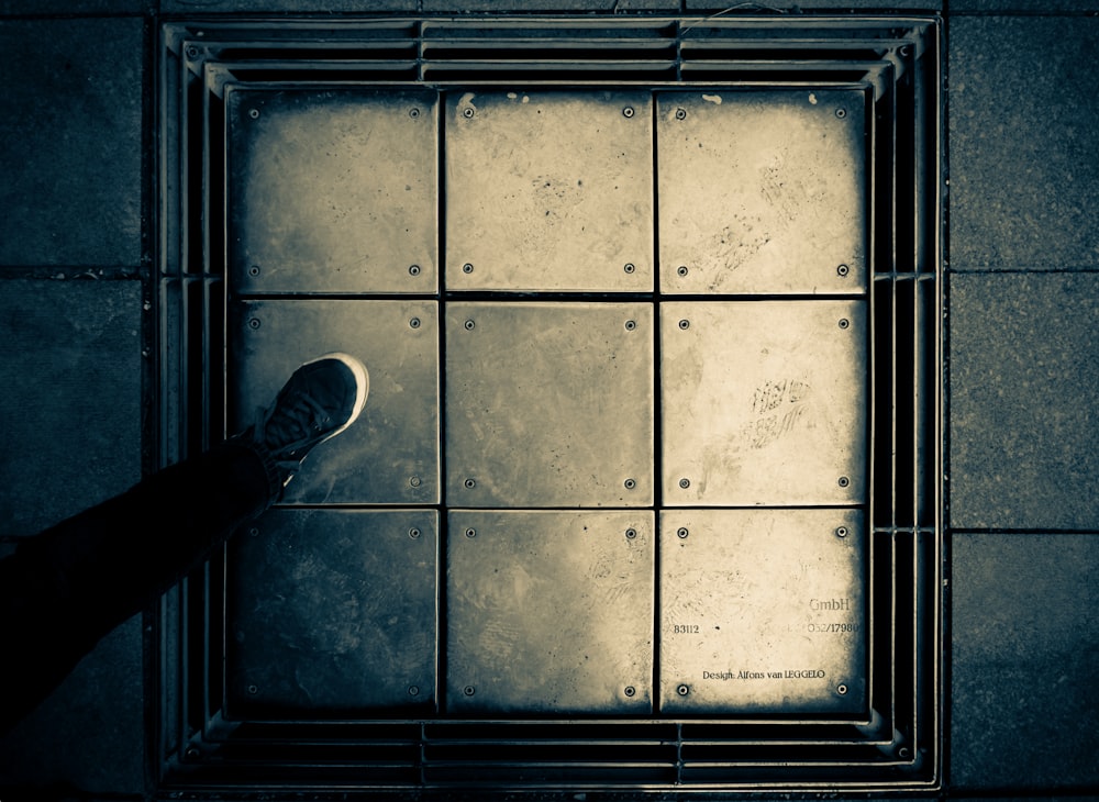 a person standing in front of a metal grate