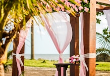 brown wooden gazebo with pink curtain