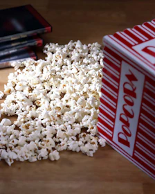 A colorful array of DVDs and video games spread out on a rustic wooden table.