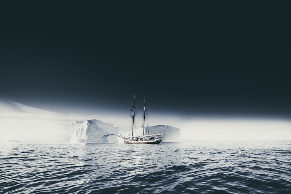 boat on body of water near ice berg