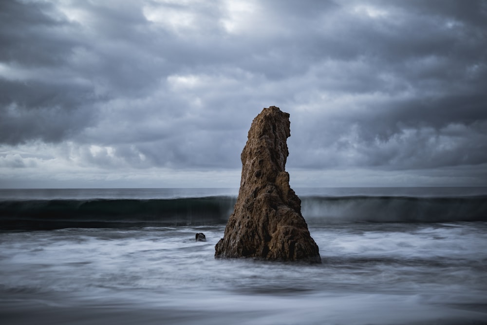 brown rock formation on sea