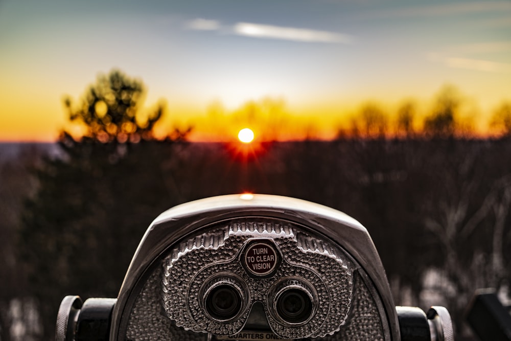 foto de foco seletivo do telescópio visualizador da torre de prata de frente para a luz do sol