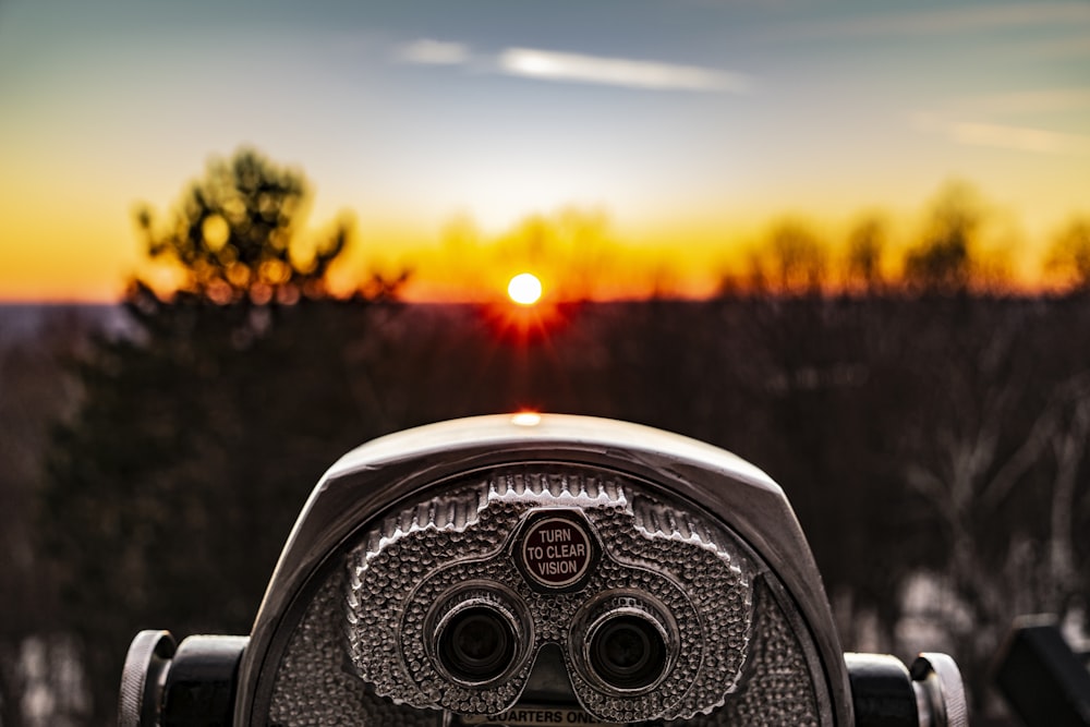 Foto de enfoque selectivo del telescopio del visor de la torre plateada mirando hacia la luz del sol