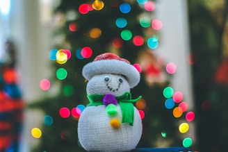Close-up of a soft knit scarf adorned with tiny embroidered Christmas trees and twinkling lights.