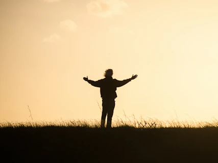 silhouette of person spreading hands
