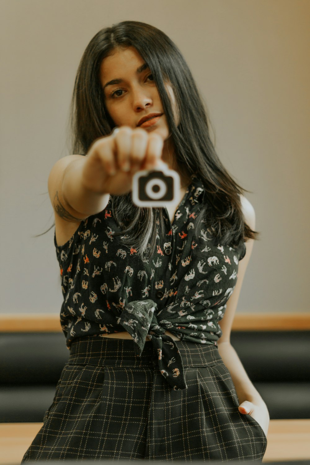 woman left hand on bottoms pocket and right hand holding out camera icon