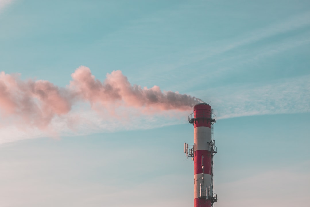  white and red lighthouse under blue sky chimney