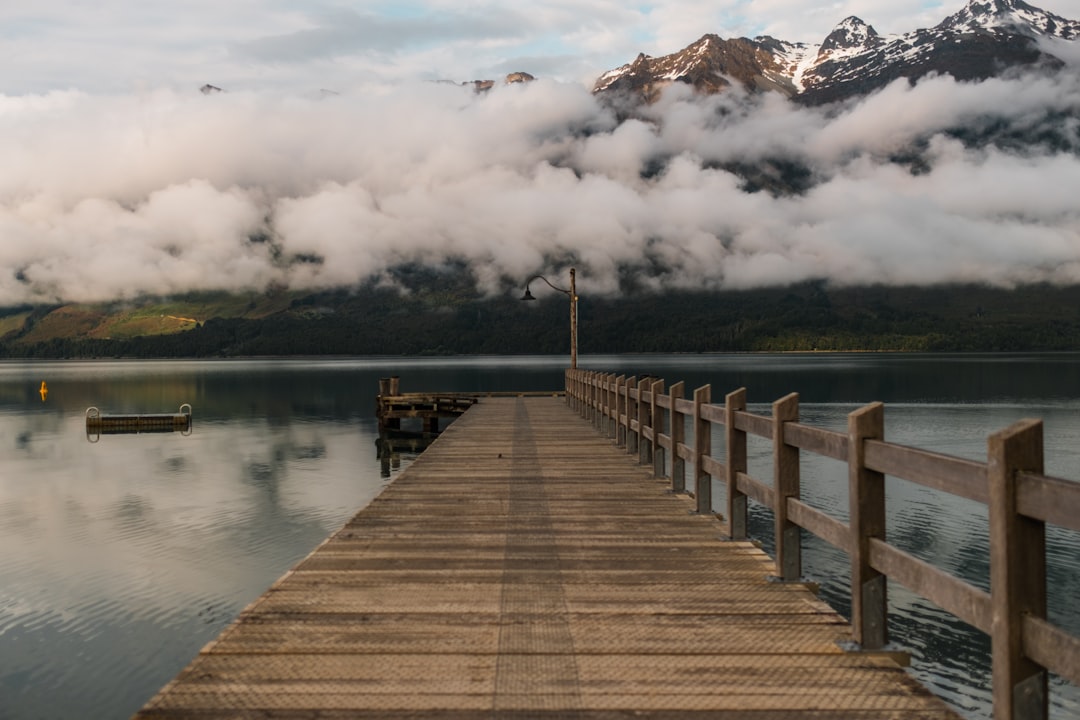 brown wooden pier under clouds