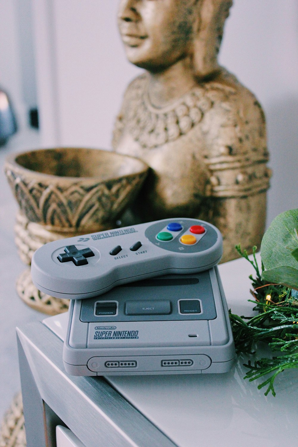 gray Super Nintendo game console with controller on table