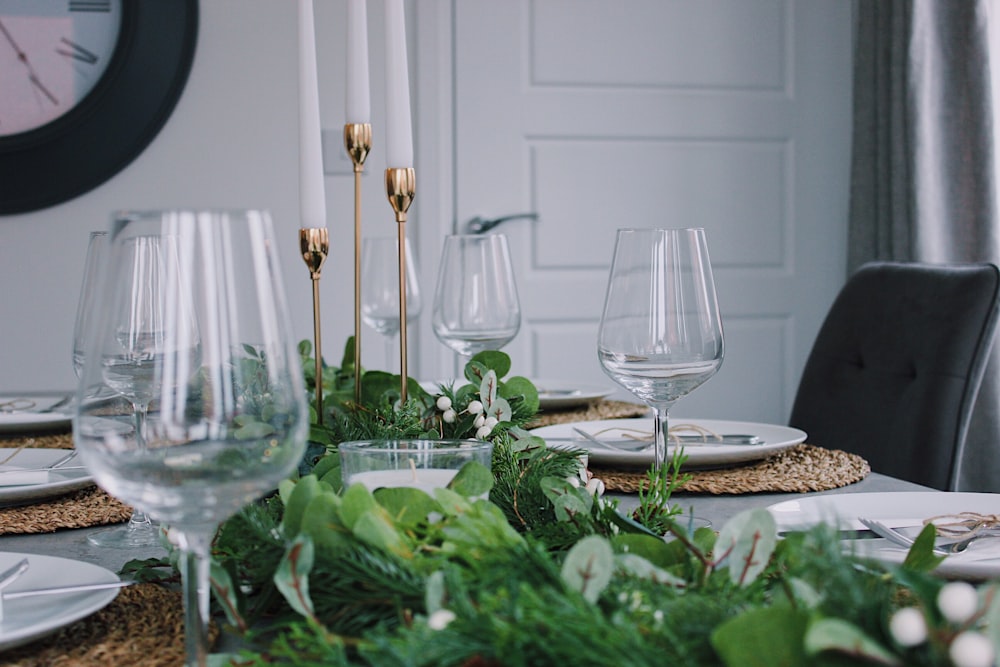 empty clear long stem wine glasses on table with plates