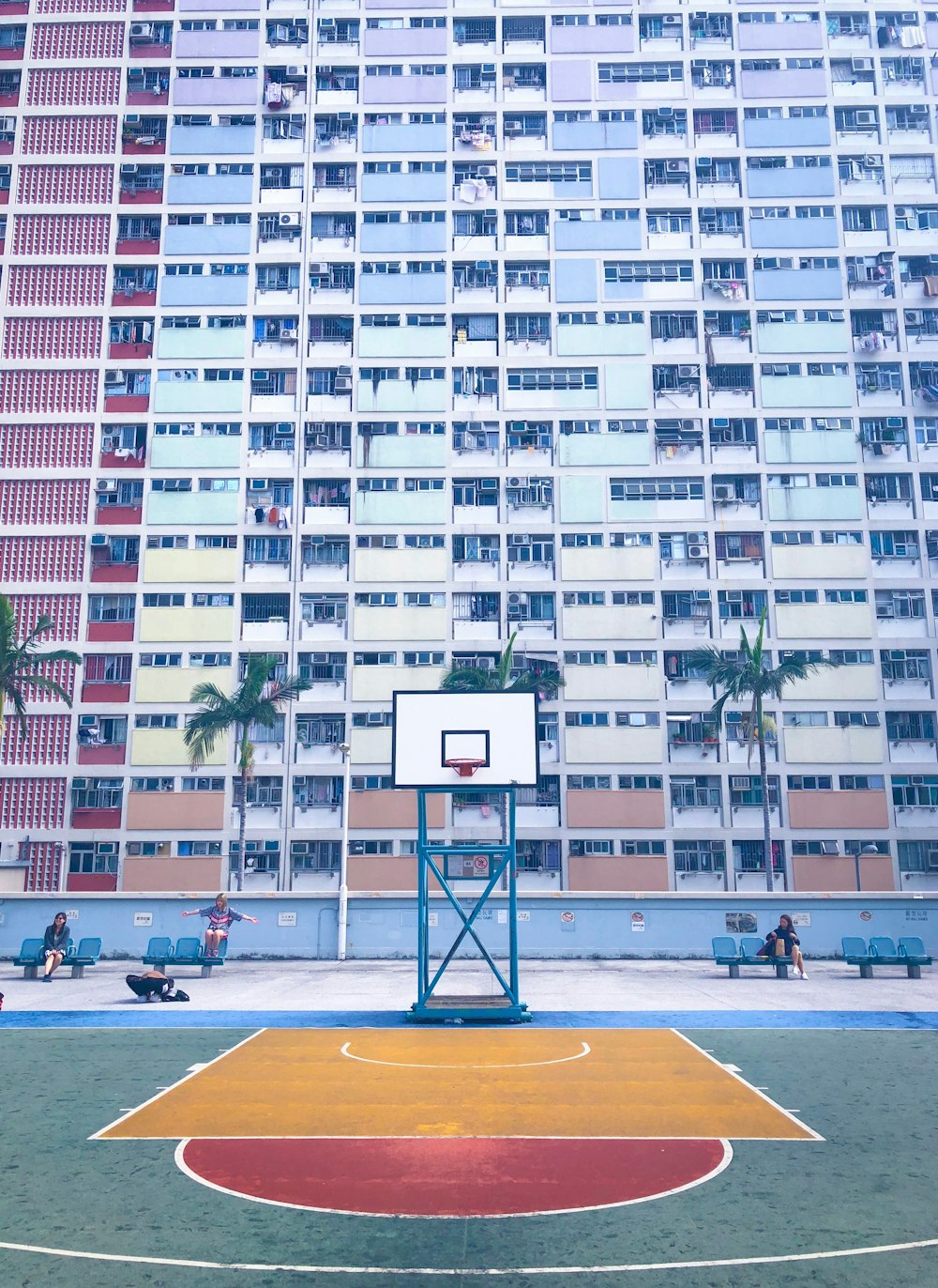 basketball court in front of concrete high-rise building during daytime
