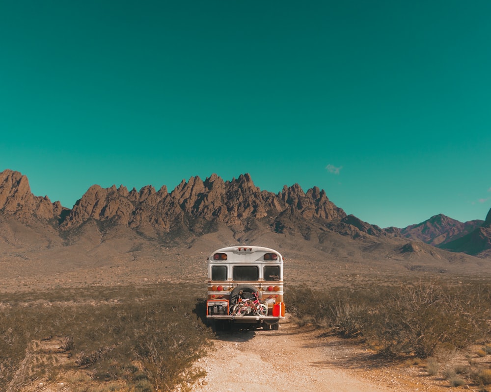 white and red bus near mountain