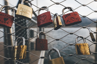 assorted-color padlocks on fence during daytime