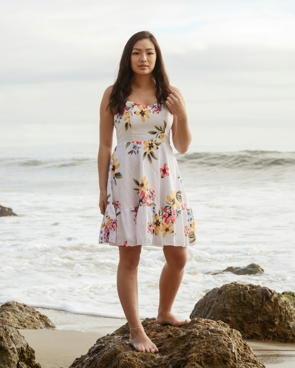 woman standing on rock on shore during daytime