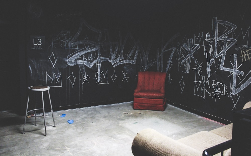 red leather sofa chair beside graffiti wall