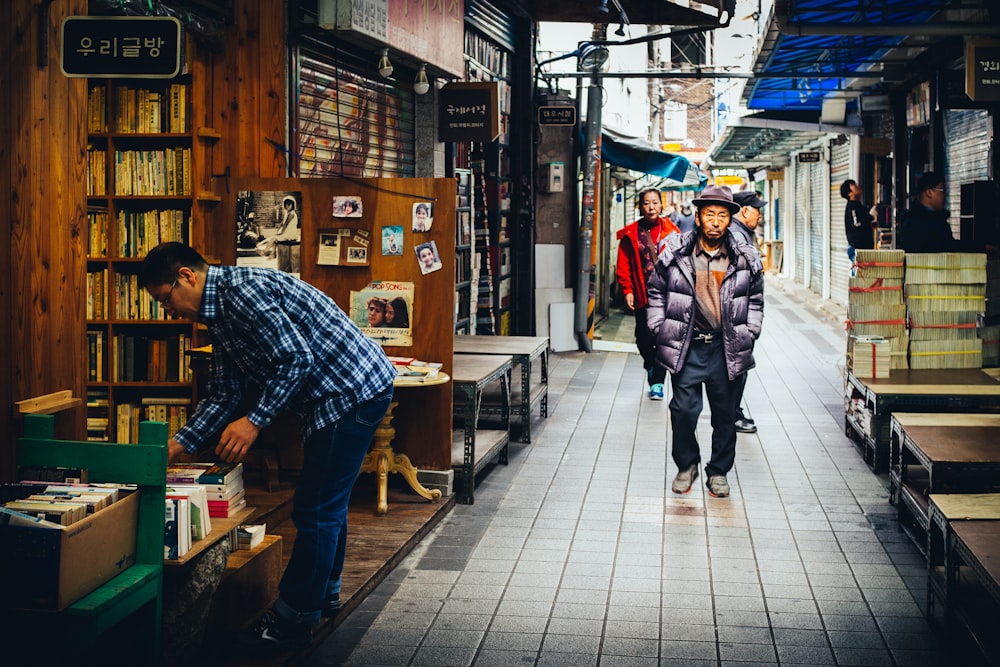 men walking along narrow pathway in market