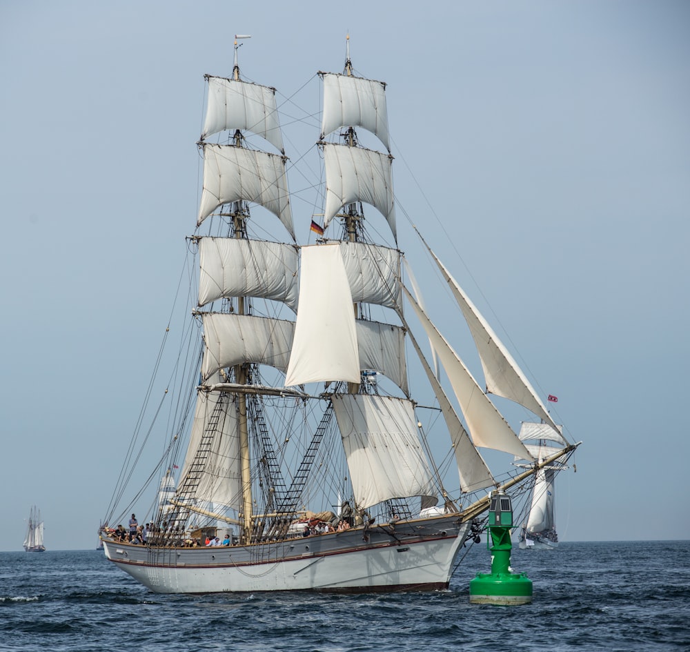 white clipper ship on body of water during daytime