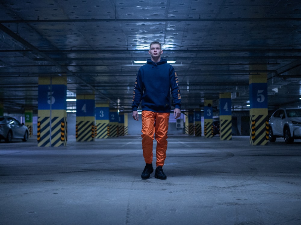 man in blue hoodie standing on vehicle garage