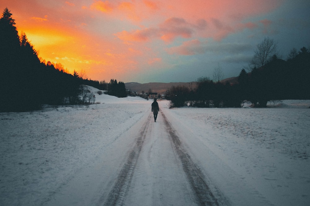 person walking along on tire track on snow