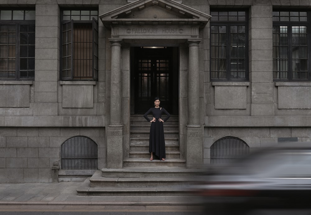 mulher em pé na frente do edifício de concreto cinza