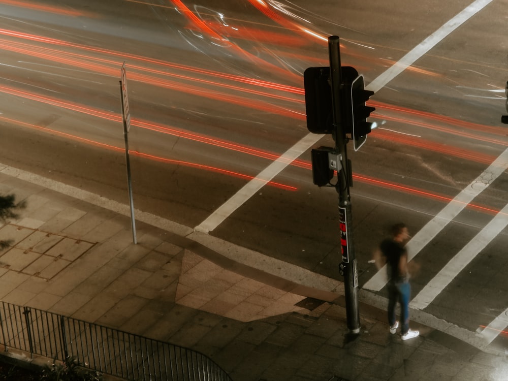 man standing beside black traffic light