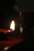 Close-up of hands cradling a glowing singing bowl surrounded by soft candlelight.