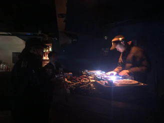 Vibrant neon-lit DJ mixing tracks in a dark club setting with blue and purple lights.
