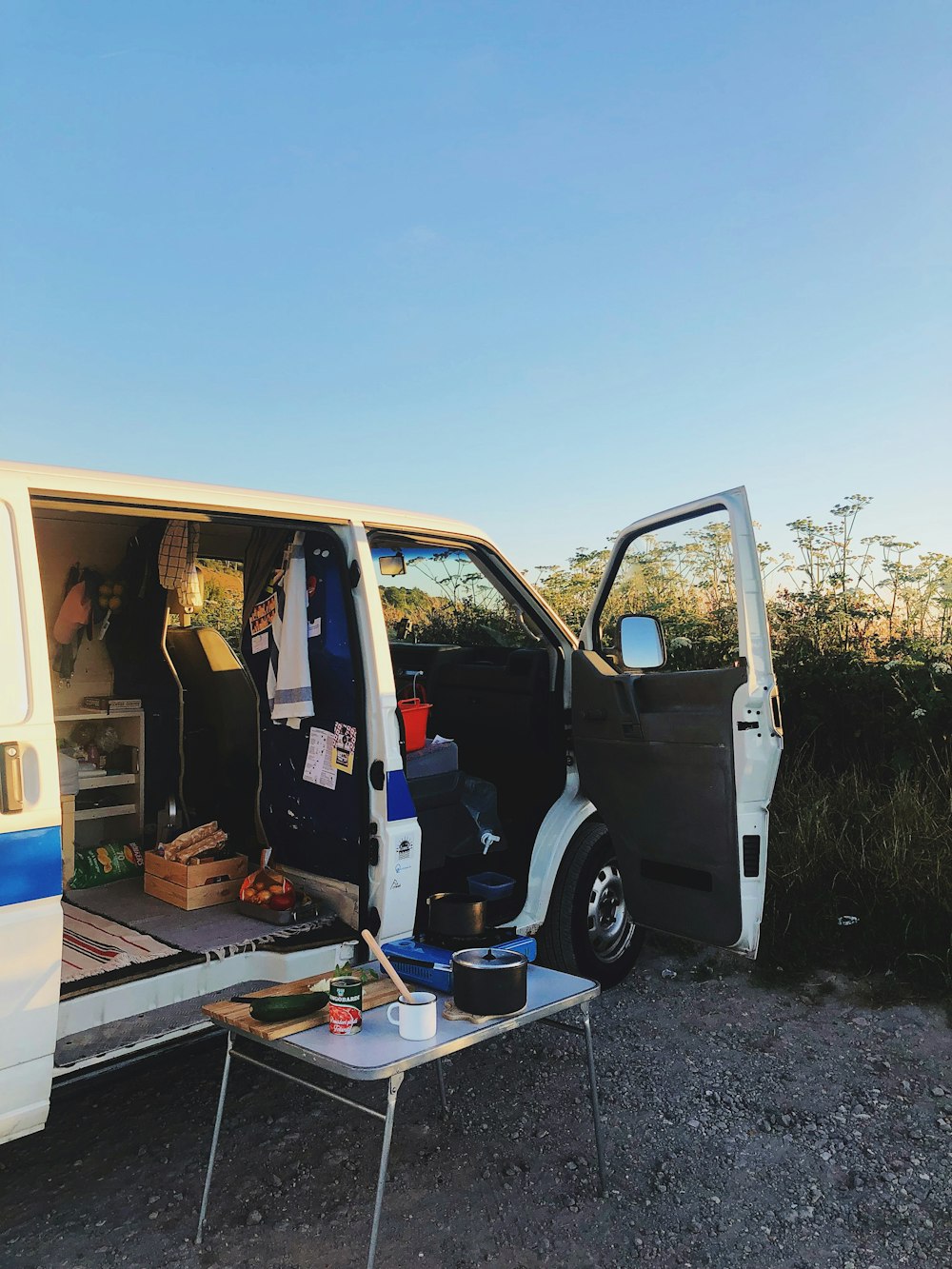 opened white van parking front of green field