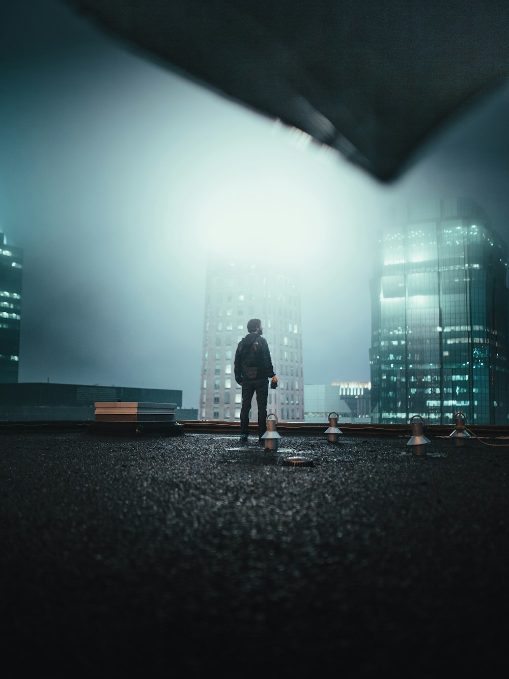 man standing on roof top at night