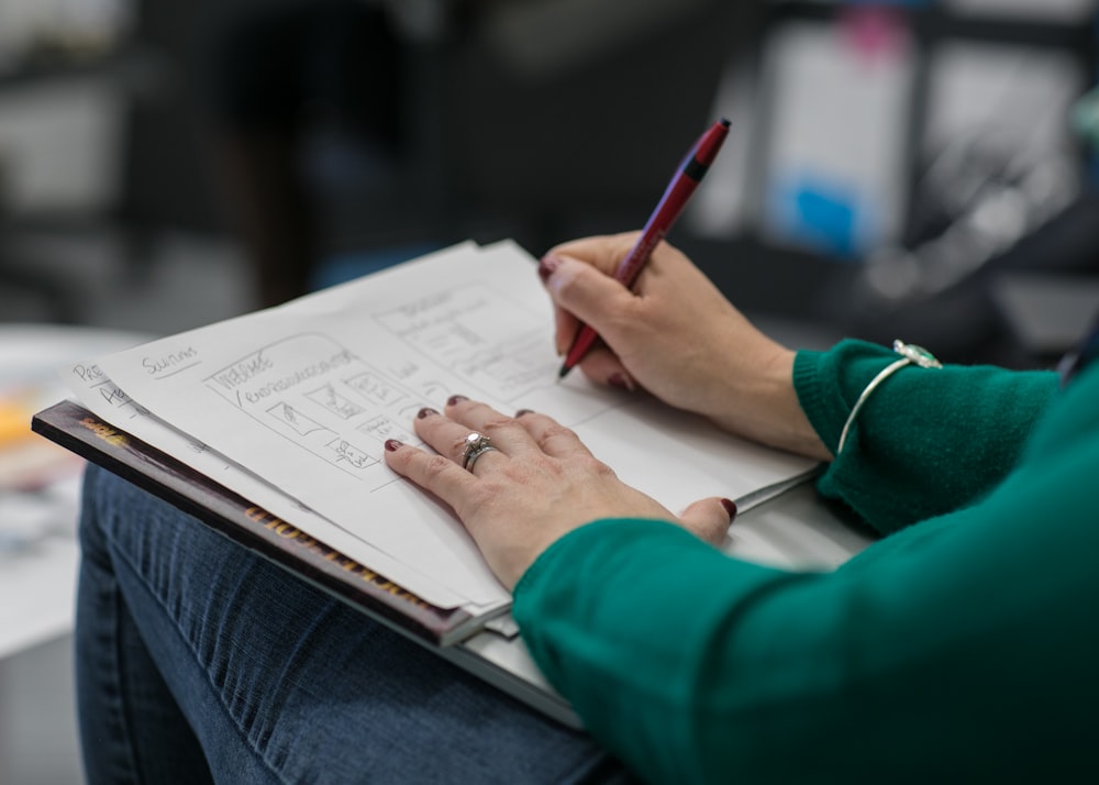 person writing on paper at lap