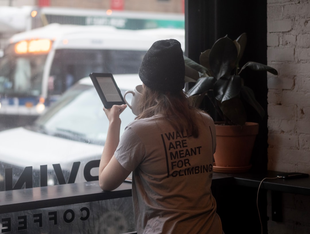 woman having coffee while using tablet