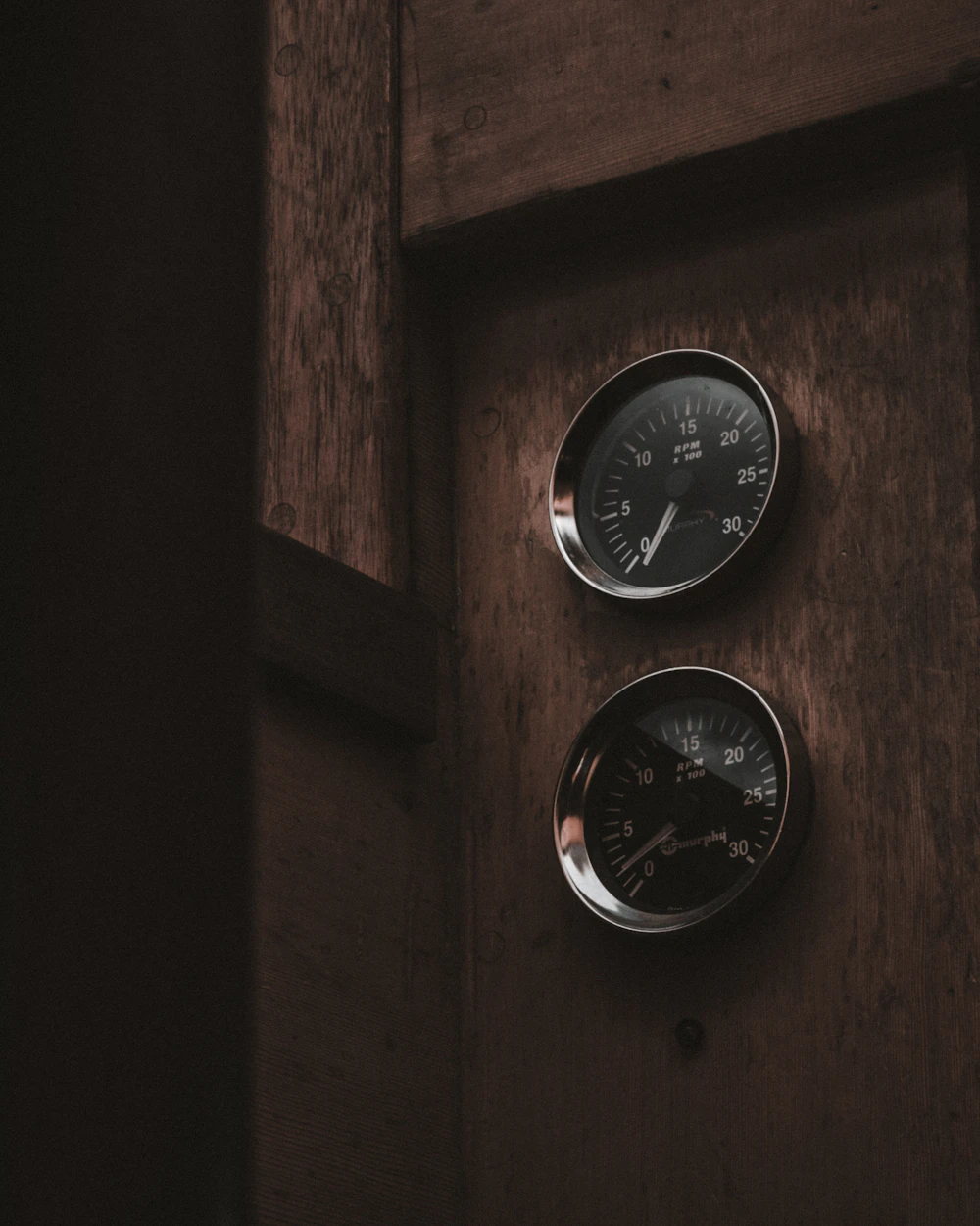 Analog gauges set into dark varnished timber